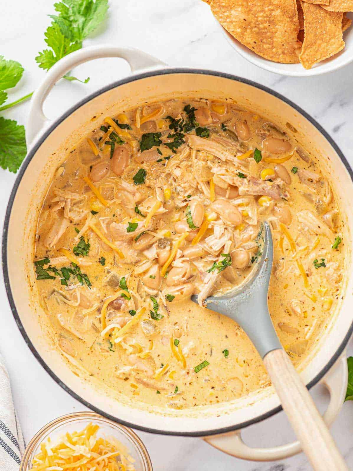 white chili chicken in a pot after being cooked with a spoon in the pot