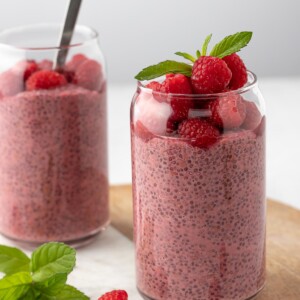 Raspberry Protein Chia Seed Pudding, topped with fresh raspberry and mint leaf on top served on a marble tray