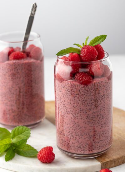 Raspberry Protein Chia Seed Pudding, topped with fresh raspberry and mint leaf on top served on a marble tray