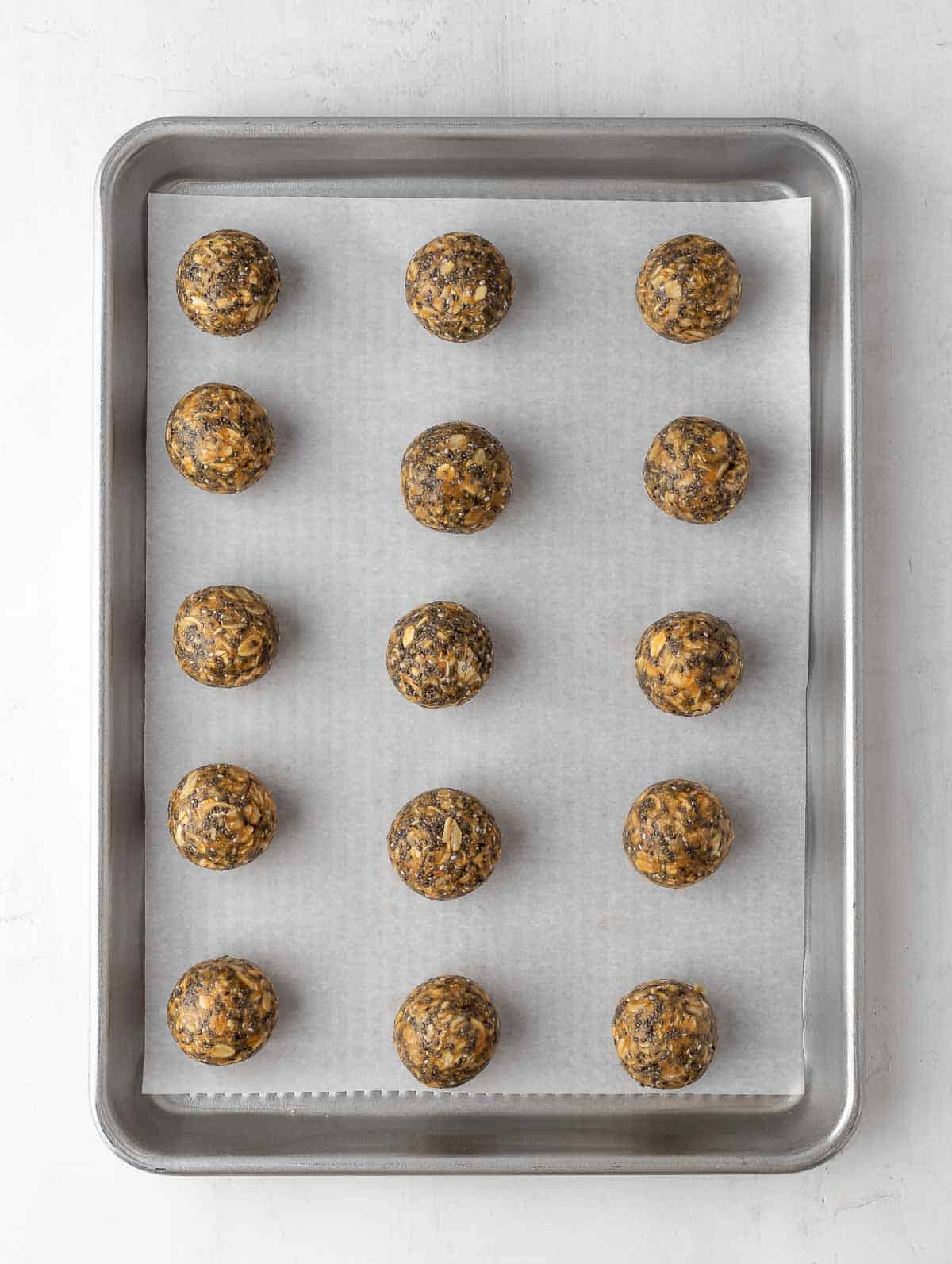 energy balls laid out on a sheet pan to cool