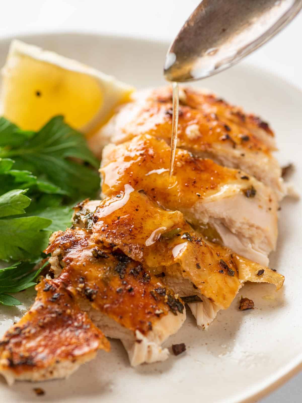 Sliced chicken breast with juices drizzled over top.