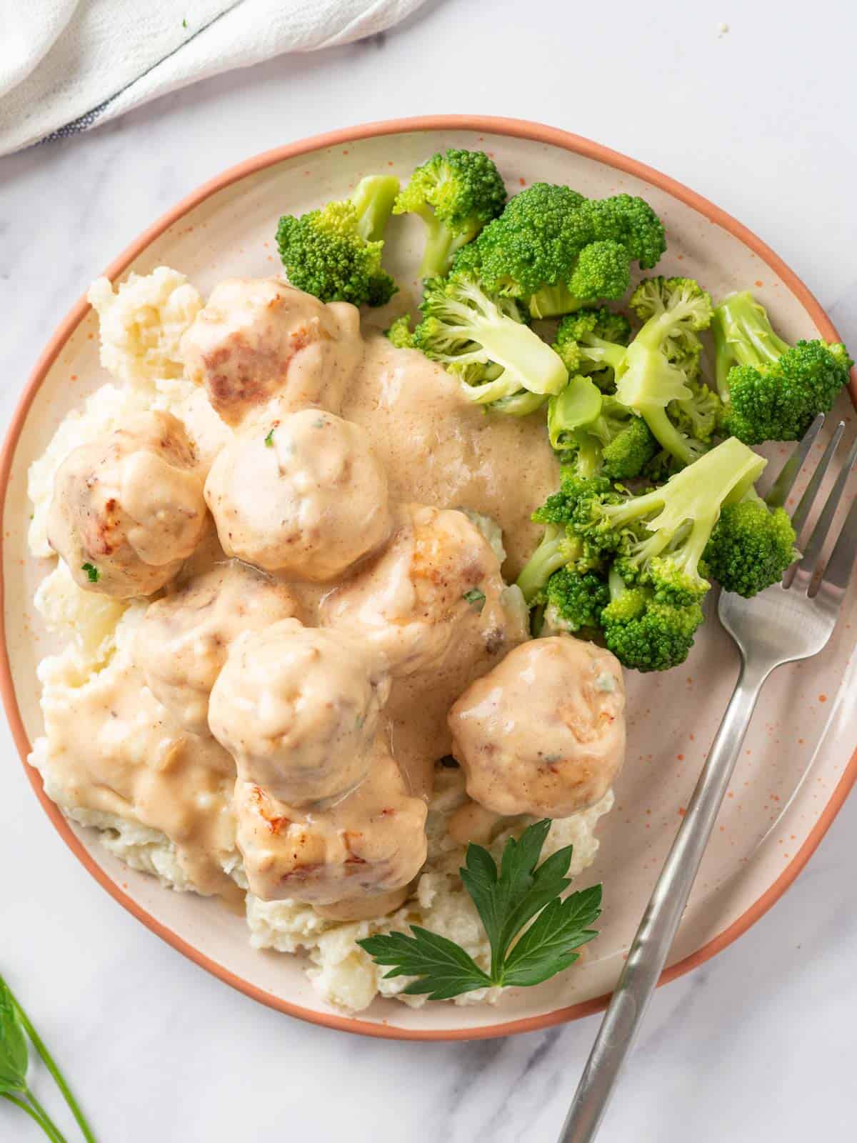 A plate of Swedish meatballs with broccoli.