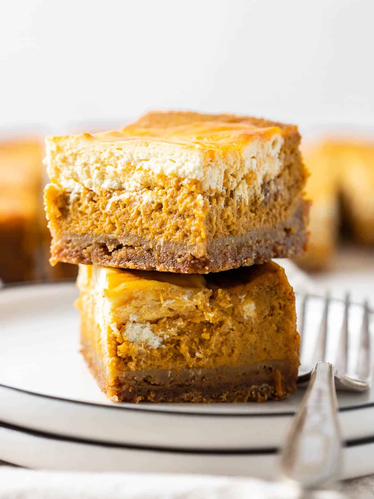 two stack of Cheesecake Swirled Pumpkin Bars on a plate