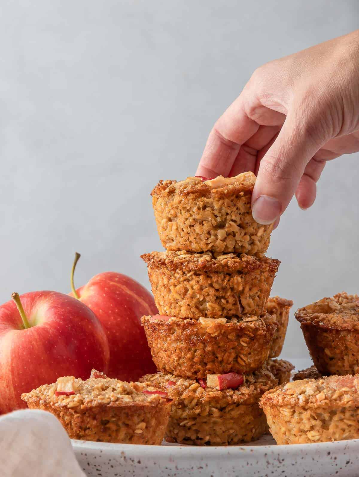 Cinnamon baked apple oats cups stacked on top of each other on a plate.