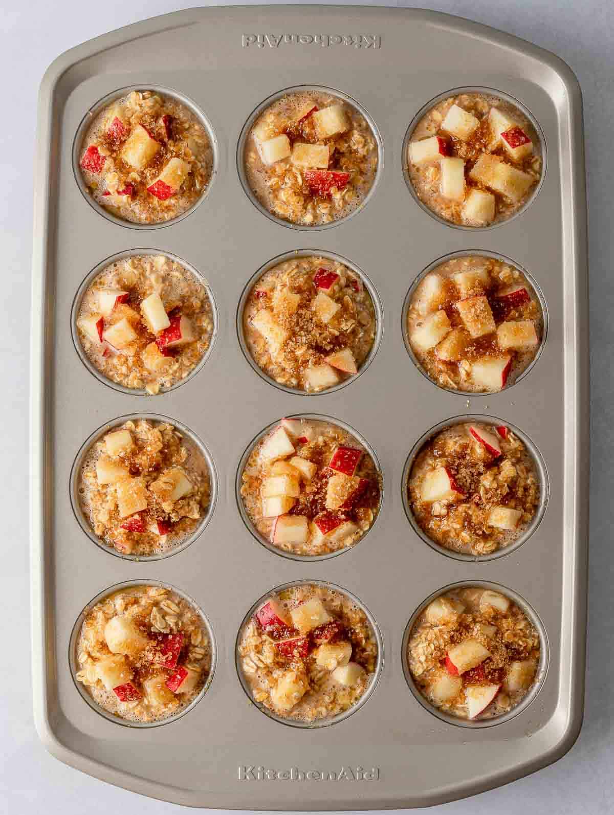 Overhead view of cinnamon baked apple oats cups in a muffin tin.