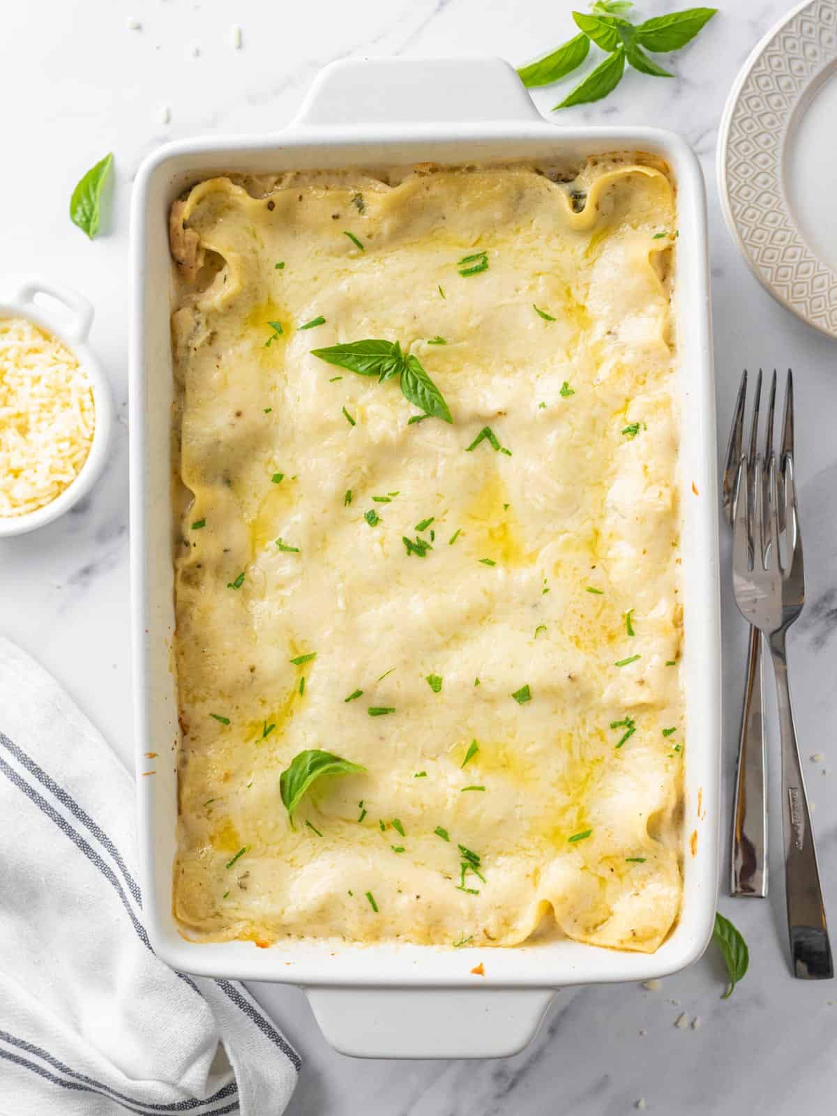 A baked Creamy Chicken Lasagna in a white pan.