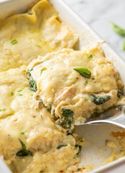 A slice of Creamy Chicken Lasagna being lifted from the pan.