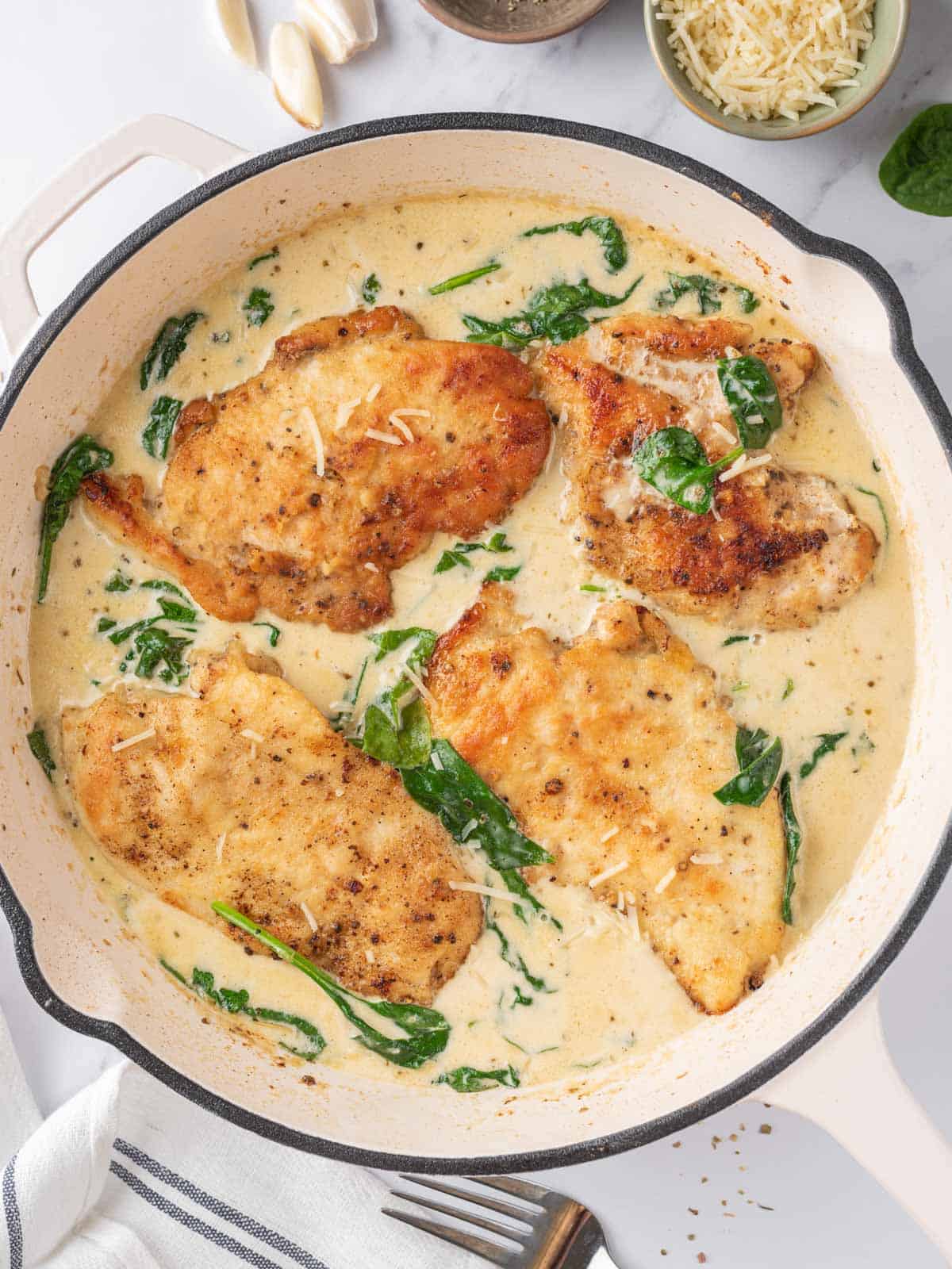 creamy chicken florentine in a white skillet after being cooked