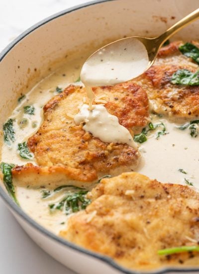creamy florentine sauce being drizzles onto the chicken