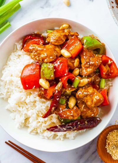 A bowl of kung pao chicken with rice.