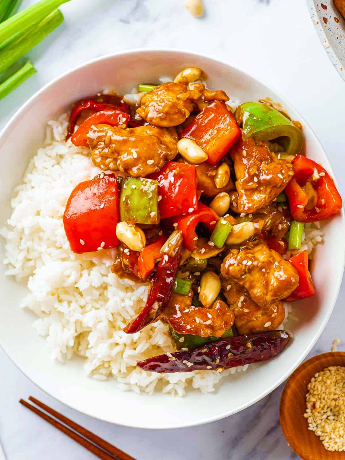 A bowl of kung pao chicken with rice.