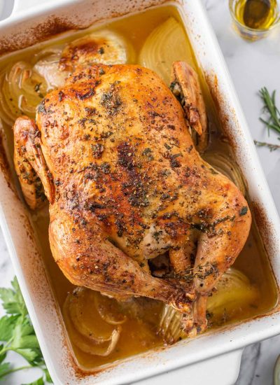 A whole roasted chicken in a baking dish.