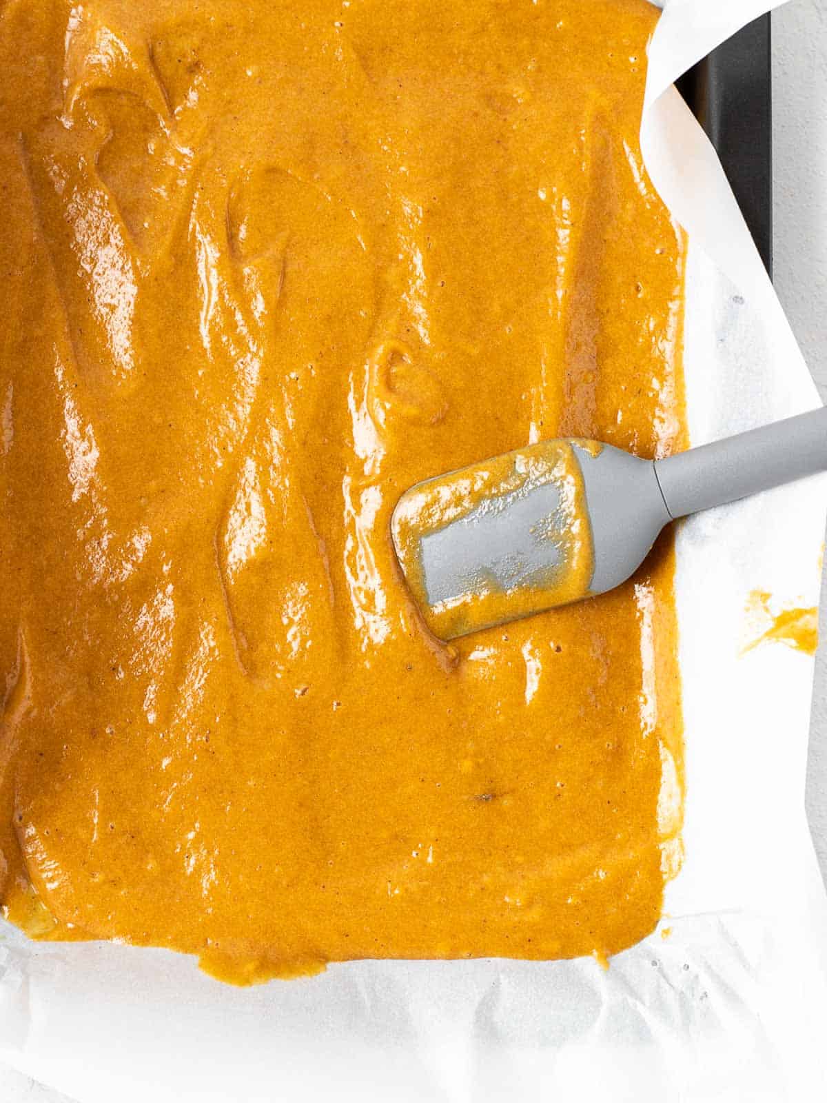 pumpkin cake batter spread on a pan