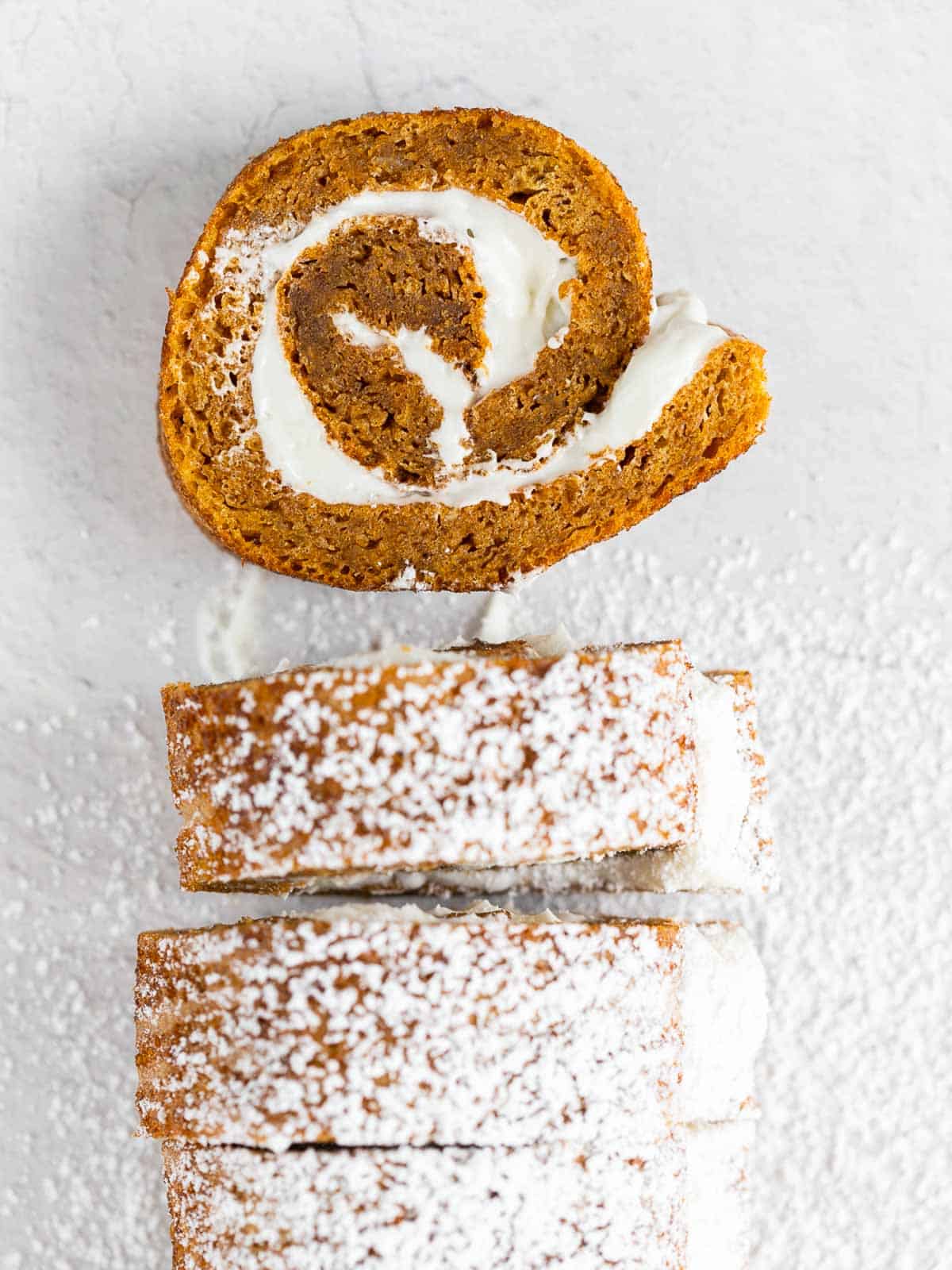 pieces of pumpkin cake roll cut out and dusted with powdered sugar