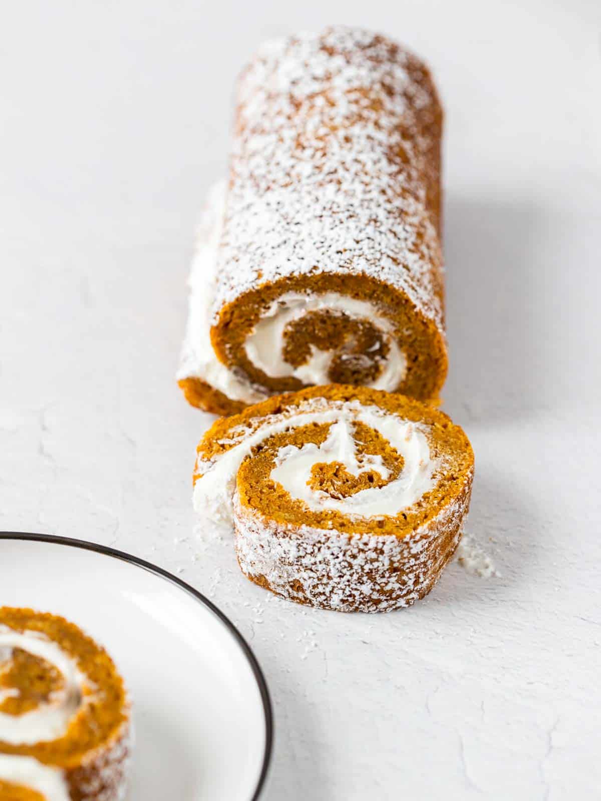 a roll of pumpkin cake with a slice cut out