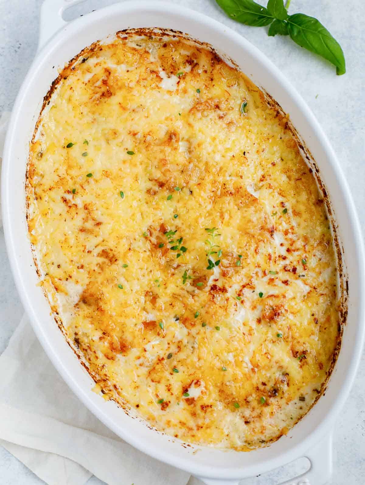 Top down shot of the au gratin potatoes in a white dish.