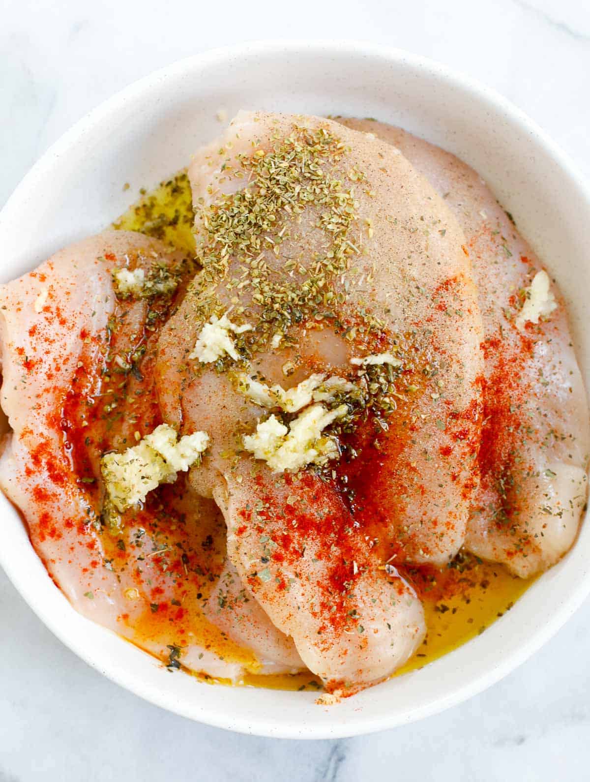 chicken breast seasoned in a bowl