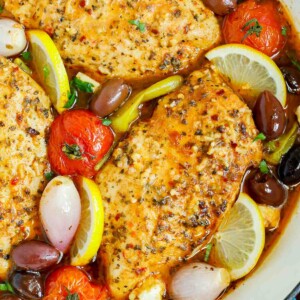 Close up of a pan of oven baked Greek chicken breasts.