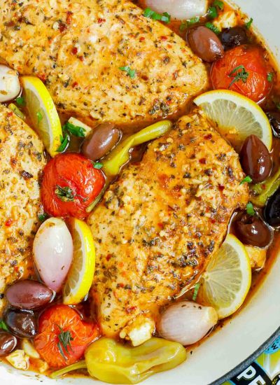 Close up of a pan of oven baked Greek chicken breasts.