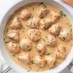 Swedish chicken meatballs in creamy gravy garnished with fresh parsley.