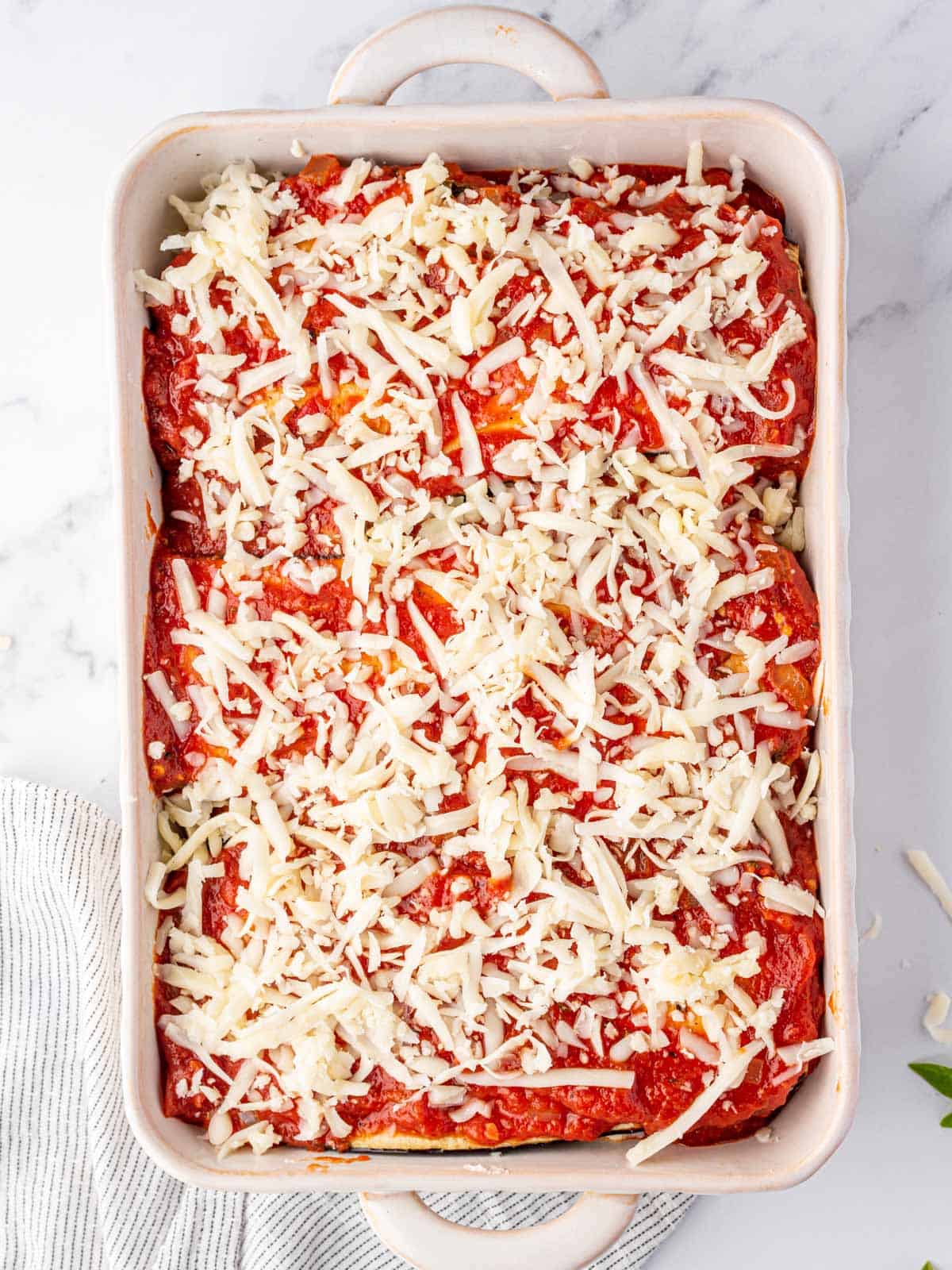 assembled eggplant parmesan in a baking dish before baking