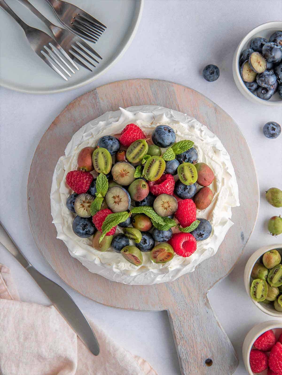 top down shot of berry pavlova cake on a wooden board