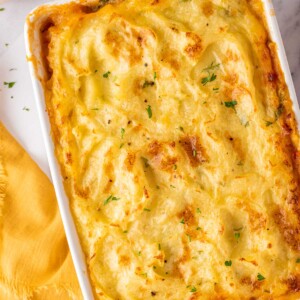 Chicken Shepherds pie in a white baking dish, garnished with parsley