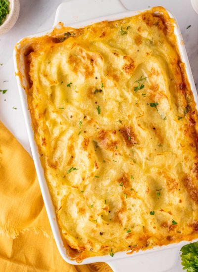 Chicken Shepherds pie in a white baking dish, garnished with parsley