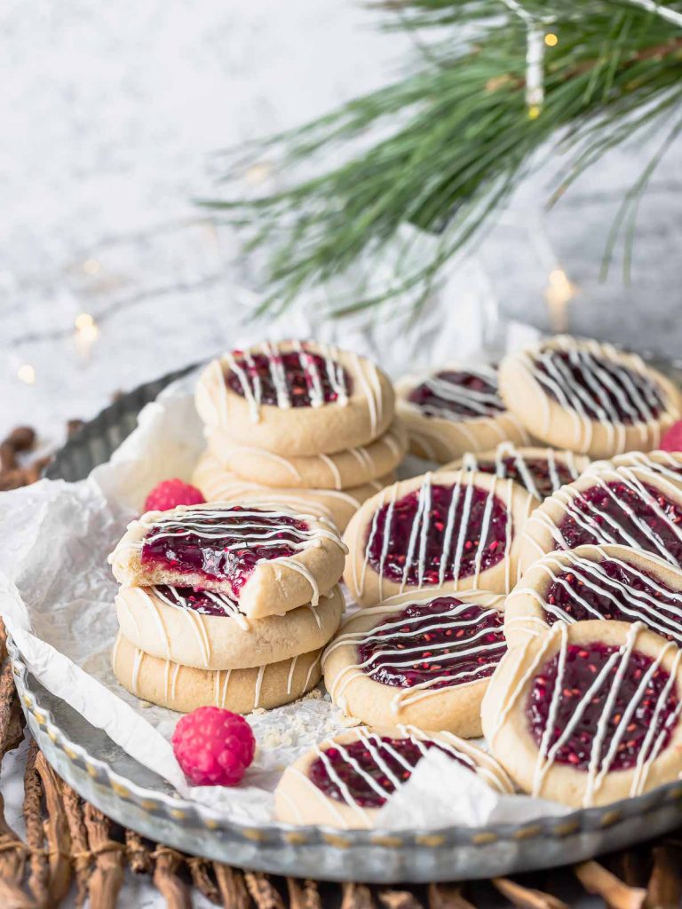 raspberry jam cookies drizzled with icing on a pan
