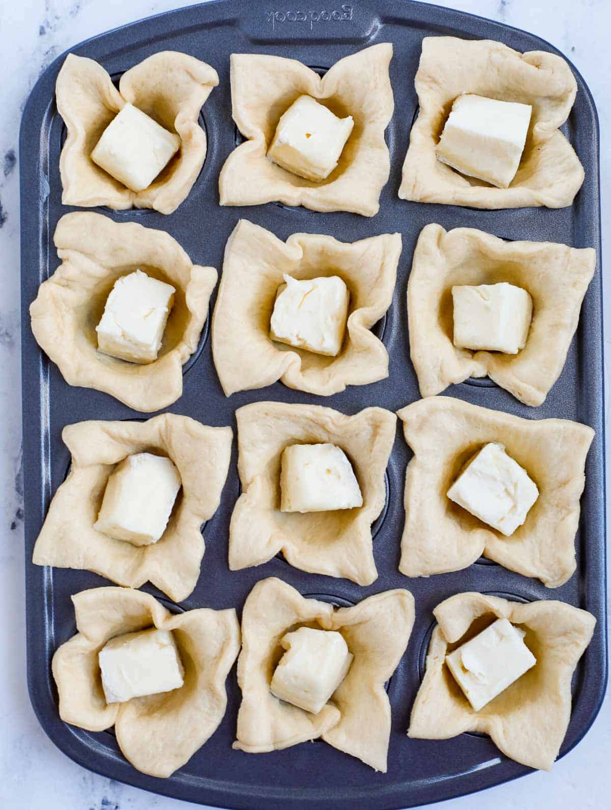 cheese in tin pan over crescent dough