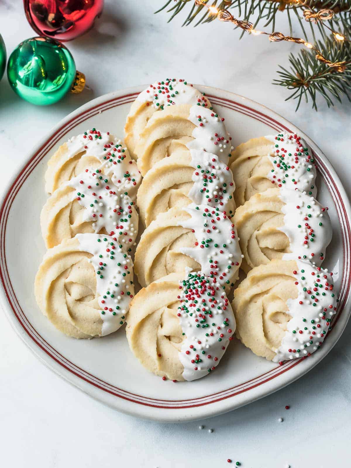 danish butter cookies dipped in white chocolate and sprinkles with red and green sprinkles