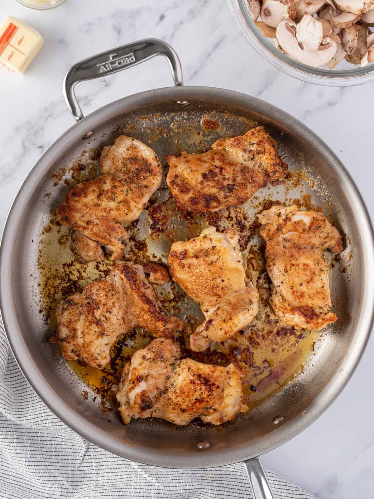A pan of seared chicken thighs.