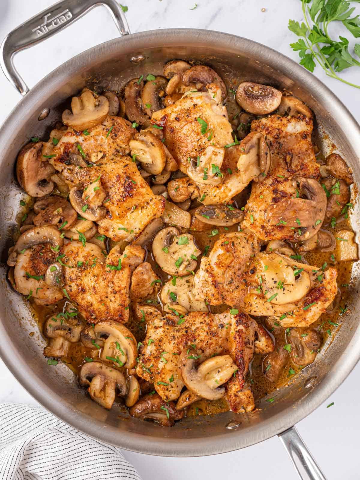 A pan of chicken thighs with garlic mushrooms.