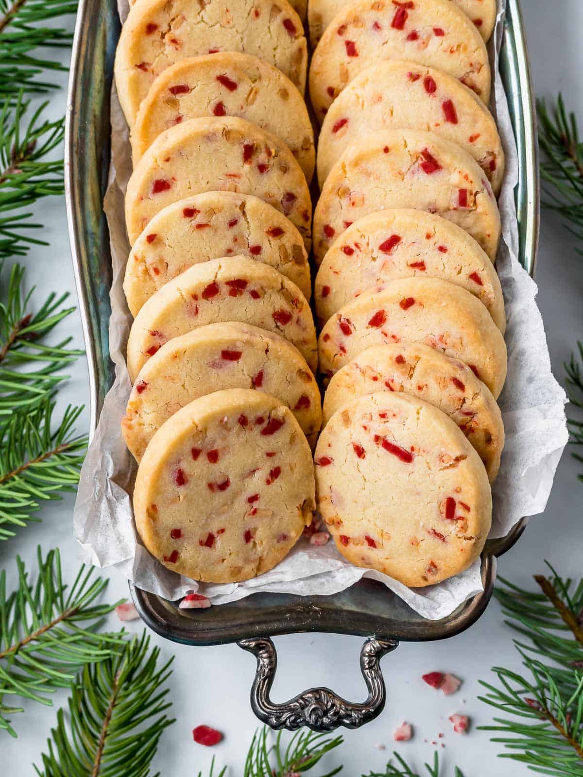 peppermint short bread cookies in a tray with greenery around it