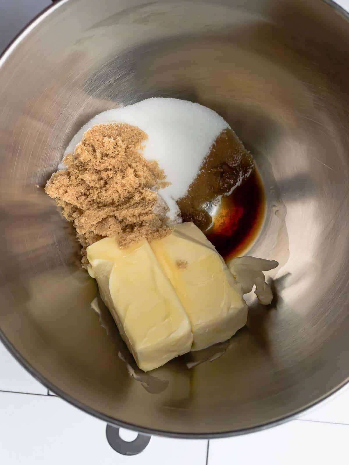 Butter with granulated sugar, brown sugar, and vanilla in a stand mixer bowl.