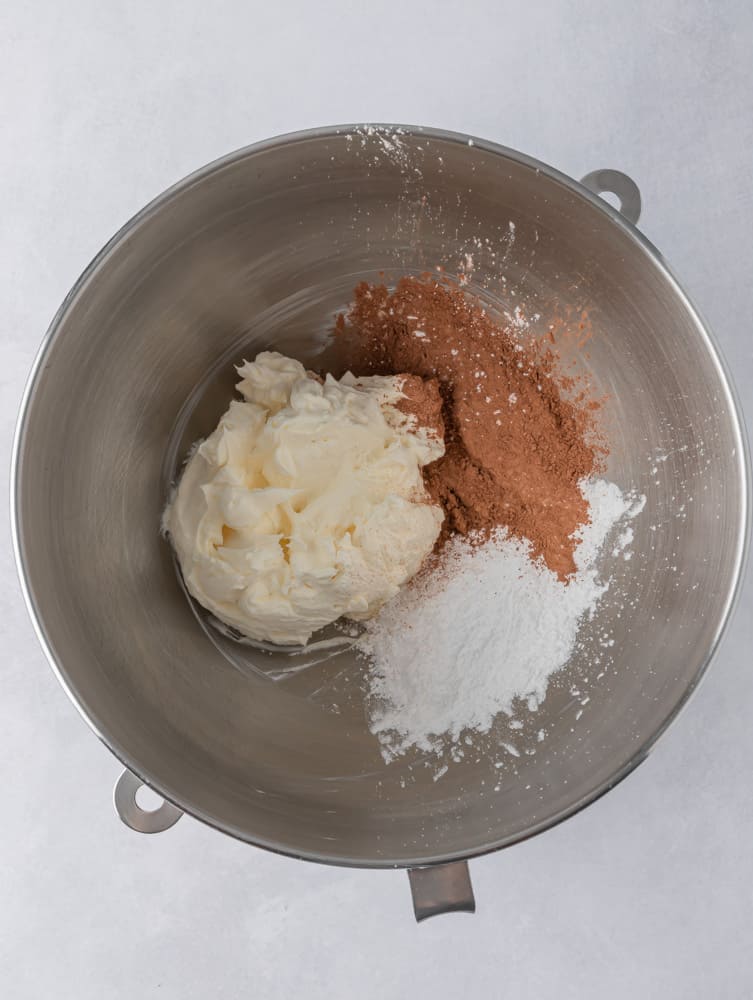 whipped cream, sugar icing, and cocoa powder in a bowl