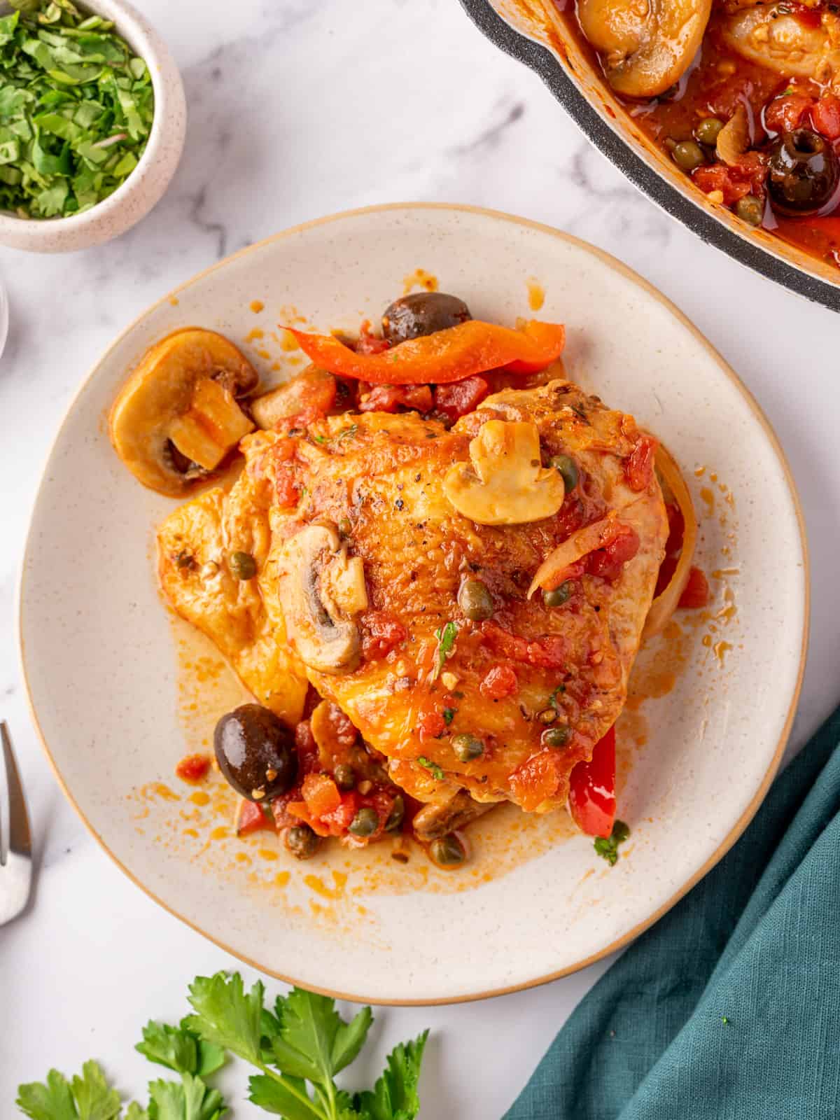 A serving on chicken cacciatore on a white plate.