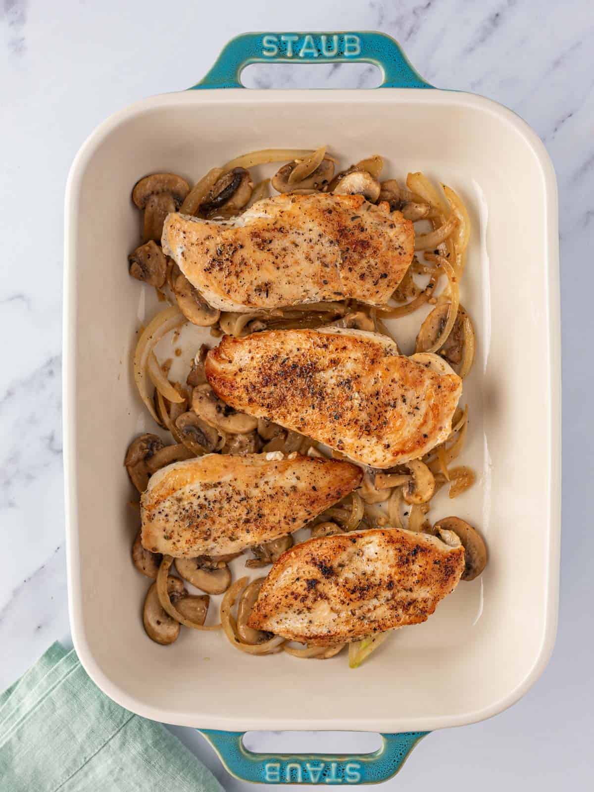 Chicken and mushrooms in a baking dish.