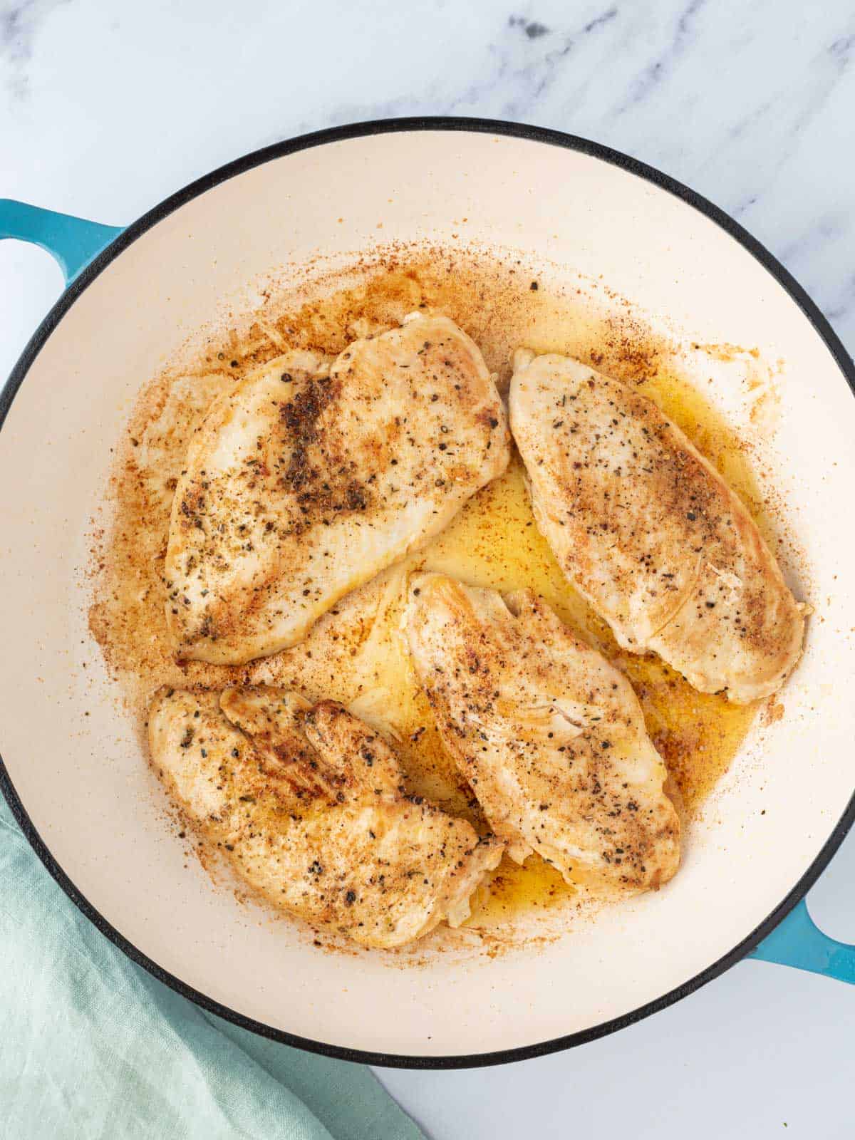 Chicken seared in a pan.