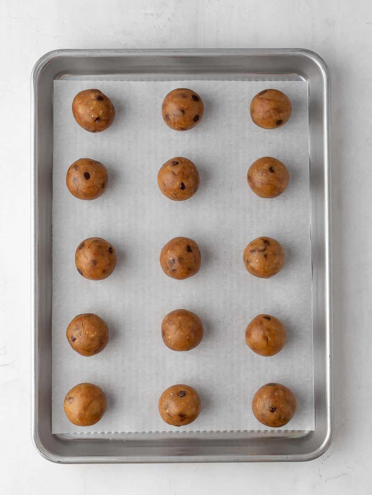 protein cookie dough balls lined up in a sheet pan