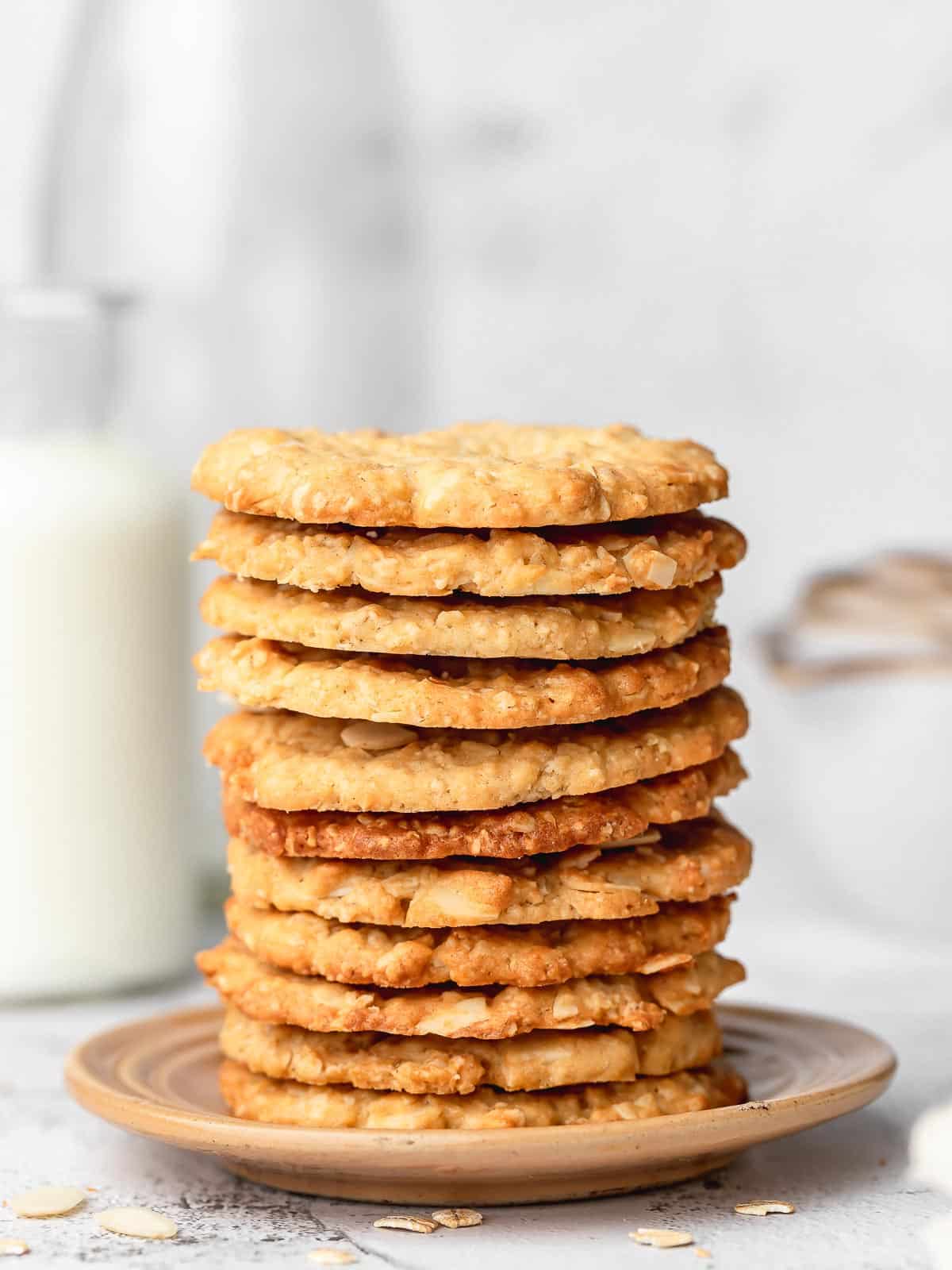 crispy almond oatmeal cookies stacked on a plate