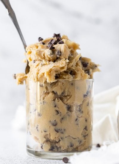 edible cookie dough in a clear glass with a spoon inside