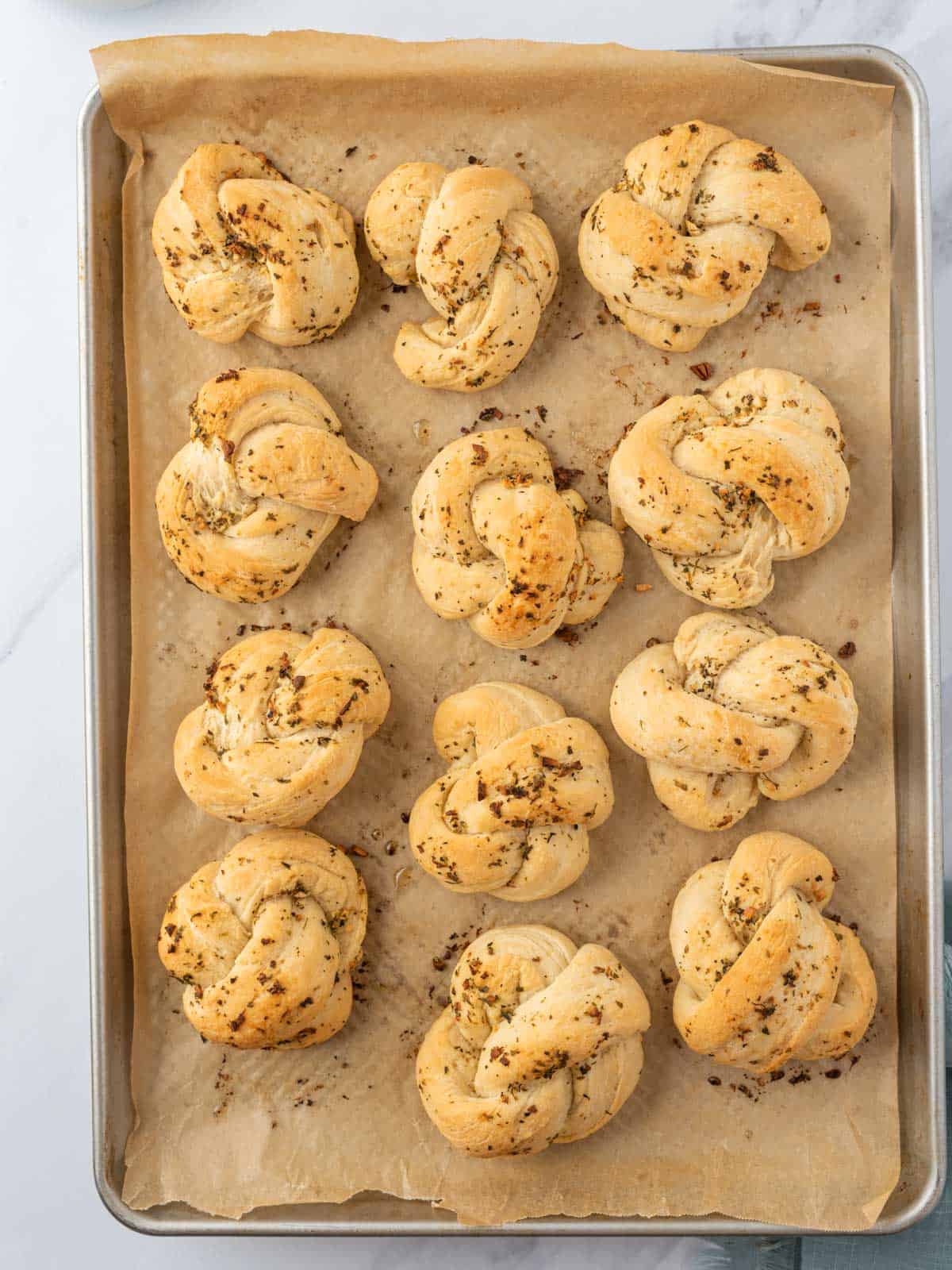 Baked garlic knots in a sheet pan.