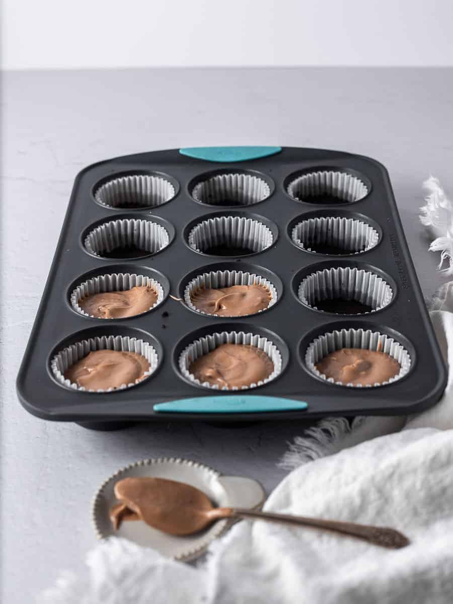 cheesecake batter placed into the cupcake tins