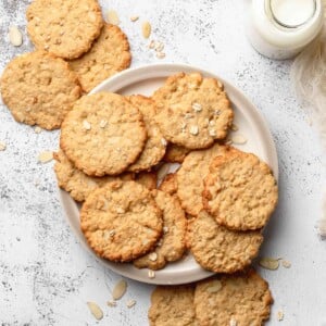 Crispy Almond Cookie on a plate with a bottle of milk next to it.