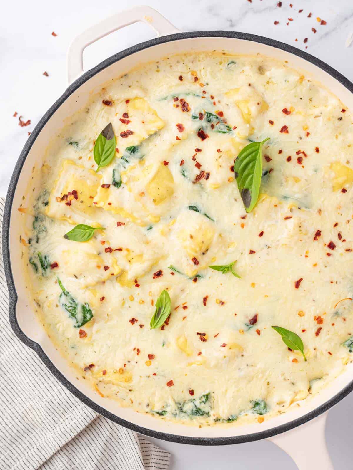 Creamy cheese and spinach ravioli in a skillet.