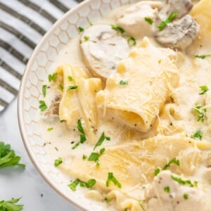 A bowl of easy white lasagna soup with a striped napkin in the background.