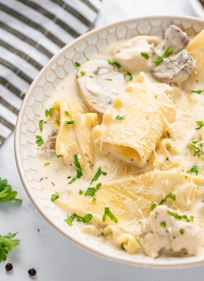 A bowl of easy white lasagna soup with a striped napkin in the background.