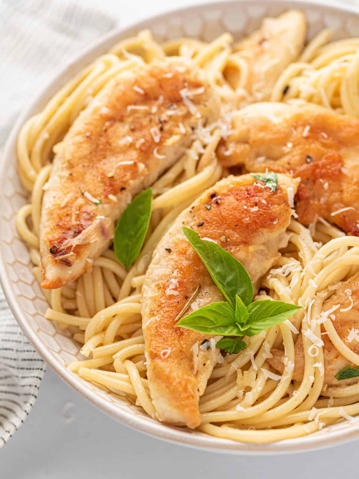 Close up of easy chicken scampi recipe with fresh basil.