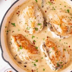 Mushroom Stuffed Chicken Breast in a white skillet with a creamy sauce..